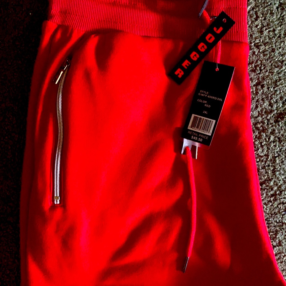 A pair of all red joggers with the zippers